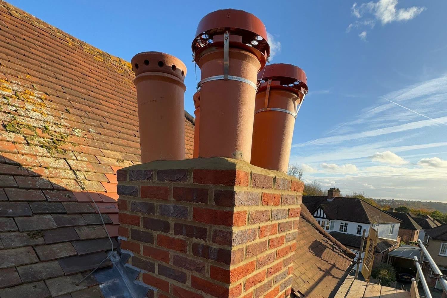 Rebuilt brick chimney stack with fresh pointing, four clay pots and new stepped lead flashing down the roof