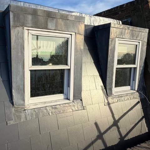 Mansard roof re-slated in dark grey slate with lead-clad dormer windows and lead capping
